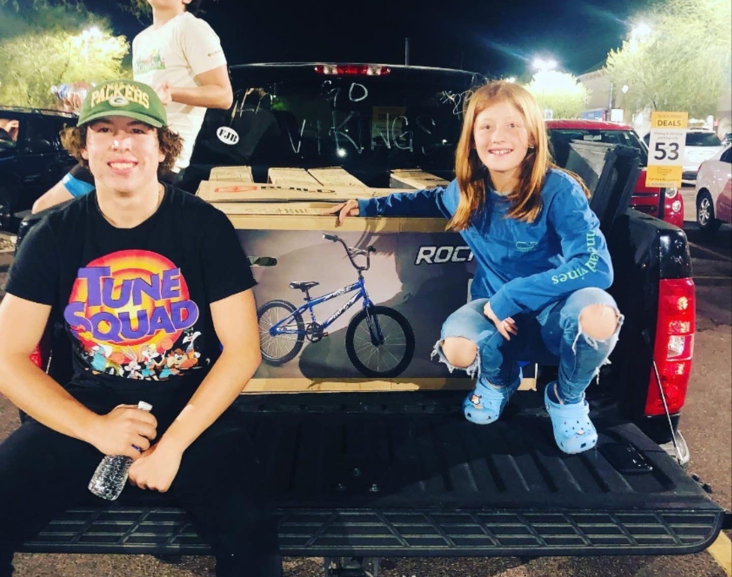 Two volunteers in front of a massive lineup of donated bikes