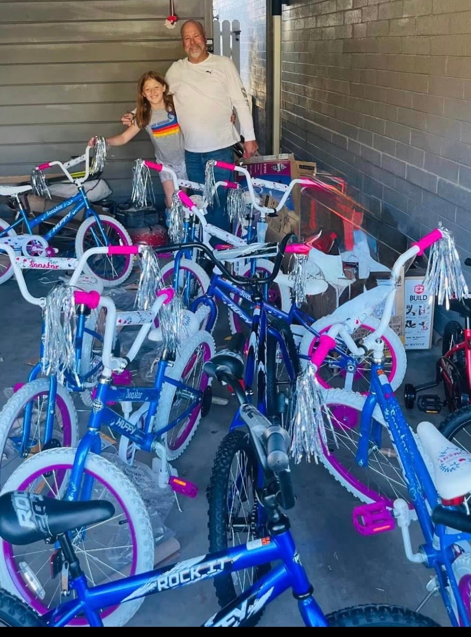 John and his daughter surrounded by decorated Huffy bikes in the family garage