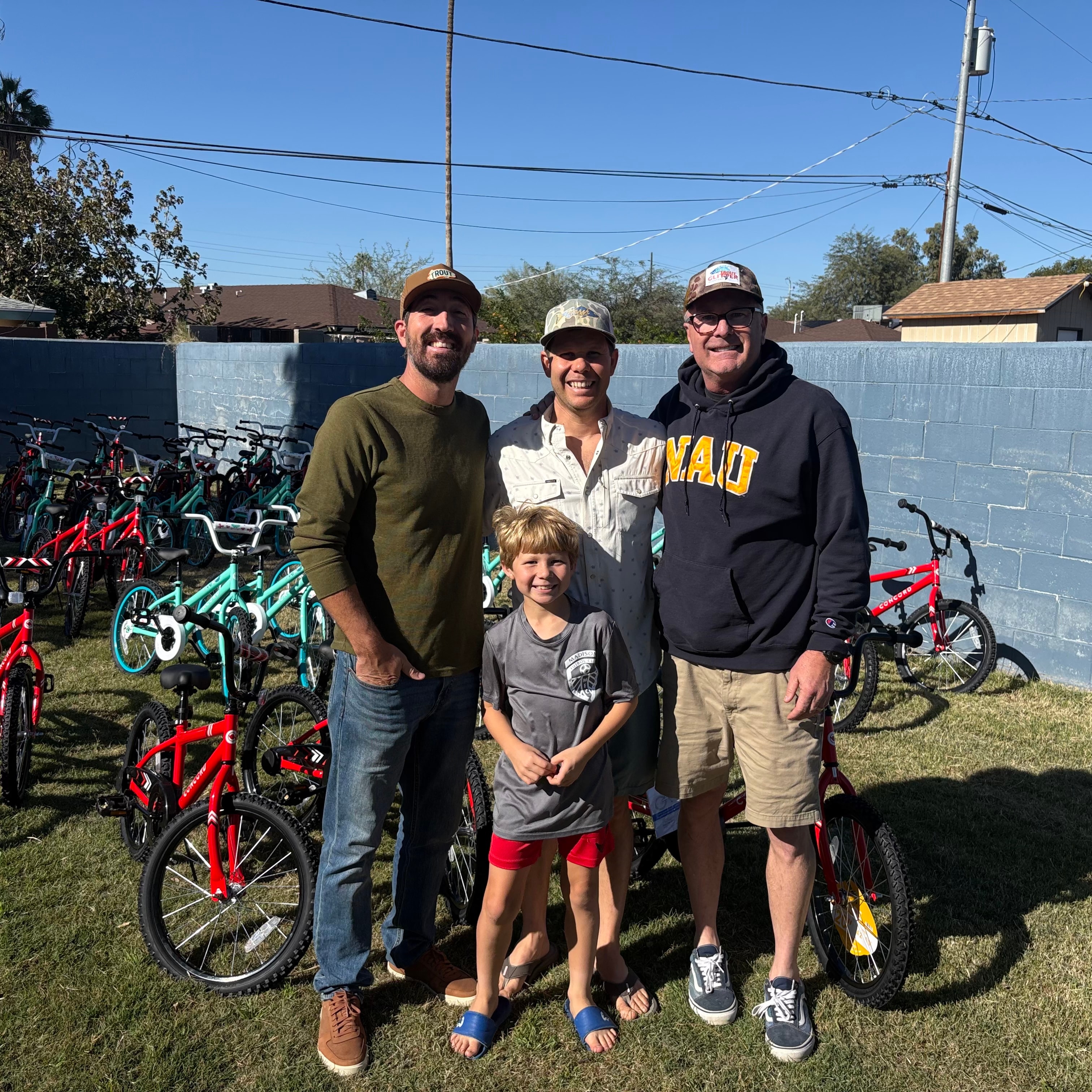 Arizona In Action team and family posing with donated bikes outdoors